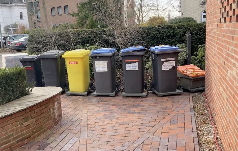 This train of trash bins moves to the curb with the press of a button
